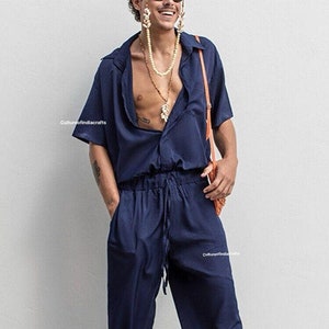 Op de afbeelding: Een donkerblauwe jumpsuit met korte mouwen en een knoopsluiting. De jumpsuit heeft een trekkoord in de taille en is gemaakt van een lichtgewicht stof.
