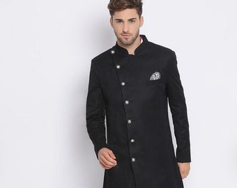 Pode incluir: Uma kurta preta de manga comprida com uma camada interior branca e um único fecho de botão. A kurta tem uma bainha diagonal e é combinada com calças brancas.