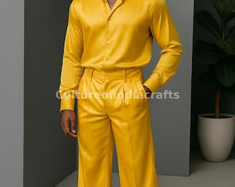 May include: A person wearing a bright yellow satin shirt and matching pants. The shirt has a collared neckline and long sleeves. The pants have a straight leg and a pleated front.