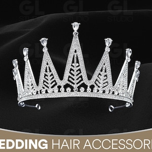 Può includere: Una corona nuziale color argento dal design scintillante, con più punte ornate da gemme trasparenti. La corona è impreziosita da numerosi piccoli cristalli trasparenti ed è posta su uno sfondo scuro. Il testo "WEDDING HAIR ACCESSORIES" è in basso.