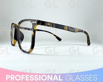Puede incluir: Un par de gafas de pasta de carey con lentes transparentes. Las gafas tienen una montura negra con un patrón marrón y dorado.