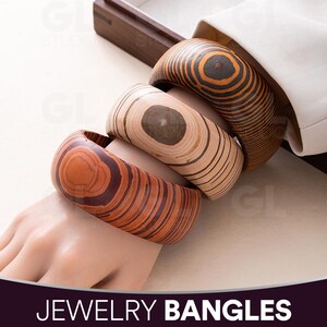 Puede incluir: Se muestran tres brazaletes de madera con patrones de vetas únicos. Los brazaletes son en tonos marrones y beige, con vetas de madera visibles. El texto "JOYERÍA BRAZALETES" está en la parte inferior de la imagen.