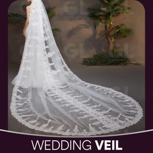 May include: A long, white wedding veil with detailed lace edging. The veil is draped, highlighting its length and delicate design. The text "WEDDING VEIL" is displayed at the bottom of the image.
