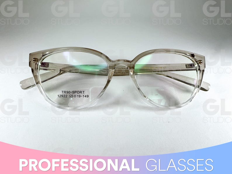 May include: Transparent-framed spectacles with a rounded shape and a subtle cat-eye design. The glasses have a clear frame and lenses, with the text "TR90-SPORT 12922 55 019-149" visible on the lens. The image also includes the text "PROFESSIONAL GLASSES".