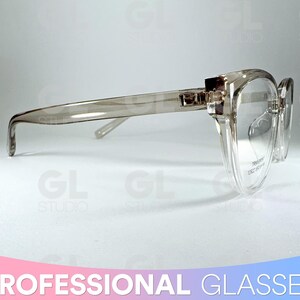 May include: Transparent, rectangular-framed spectacles with a light grey tint. The glasses are set against a gradient background. The text "PROFESSIONAL GLASSES" is at the bottom of the image. The design is modern and minimalist.