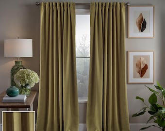 May include: Two olive green curtains hanging in a window. The curtains are made of a textured fabric and have a subtle sheen. The curtains are drawn closed, blocking out the light from the window. #16 Olive