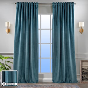 May include: A pair of teal blue velvet curtains hanging in a window. The curtains are fully drawn and the window is behind them. The curtains are lined and have a rod pocket.