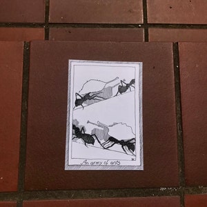May include: A black and white line drawing of ants carrying leaves. The drawing is on a white background with a black border. The text "An army of ants" is written below the drawing.