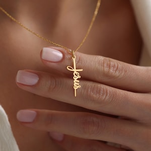 Peut inclure: Collier en or avec un pendentif en forme de croix qui dit "Jésus" en cursive.