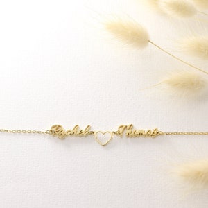 Pu&ograve; includere: Collana in oro con i nomi "Rachel" e "Thomas" separati da un ciondolo a forma di cuore.