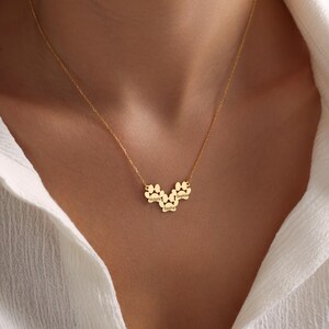 May include: Gold necklace with three paw print charms, each engraved with a name: Victoria, Sasha, and Sophie.