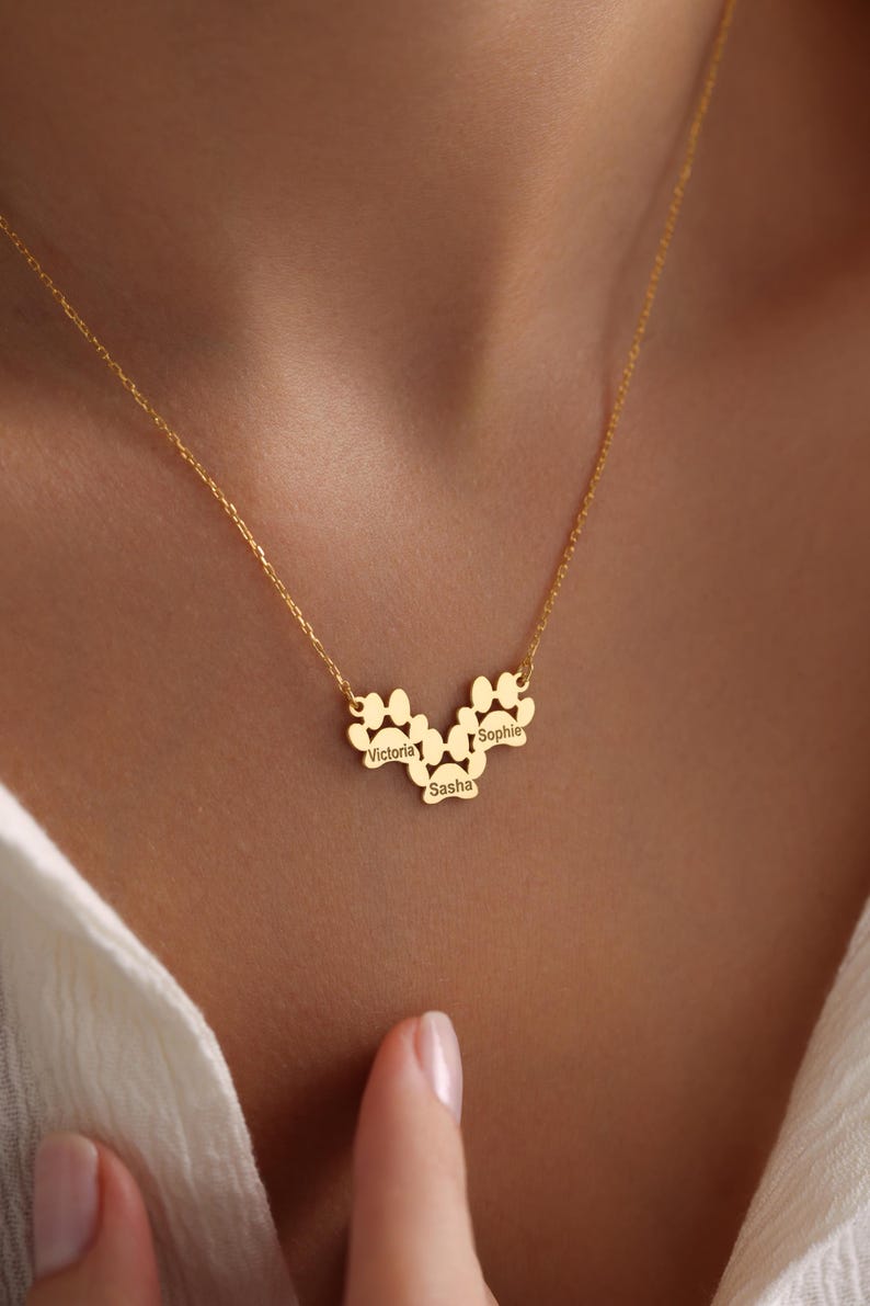 May include: Gold necklace with three paw print charms, each engraved with a name: Victoria, Sasha, and Sophie.