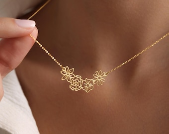 May include: A gold necklace with a delicate chain and a floral pendant featuring three cutout flowers.