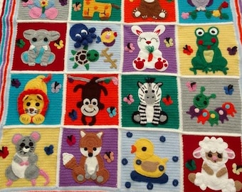 May include: A colorful, handmade crochet blanket featuring a patchwork design with various animal characters. Each square showcases a different animal, including a giraffe, bear, and zebra, with butterfly accents. The blanket is trimmed with a white, scalloped edge.