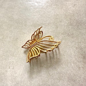 Pu&ograve; includere: Un fermaglio per capelli a forma di farfalla dorato con un design delicato e intricato. Il fermaglio ha una serie di denti sul fondo per tenere i capelli in posizione.