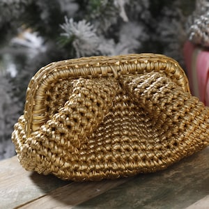 May include: A gold woven clutch purse with a rounded shape and a clasp closure.