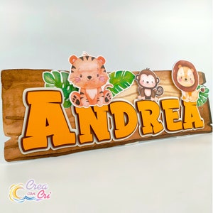 Può includere: Un cartello di legno con il nome "ANDREA" in lettere arancioni. Il cartello è decorato con una tigre, una scimmia e un leone, tutti con tratti da cartone animato. Il cartello è perfetto per una festa a tema giungla.