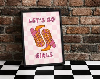 Könnte beinhalten: Ein gerahmter Druck mit dem Text "LET'S GO GIRLS" und einem Paar stilisierten rosa und orangefarbenen Cowboy-Stiefeln. Der Hintergrund ist ein rosa-weißes Schachbrettmuster. Der Rahmen ist schwarz.