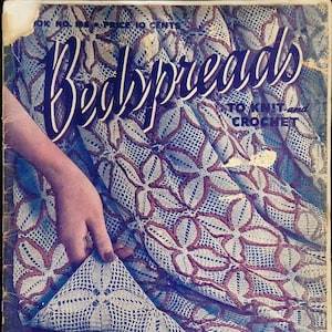 May include: A vintage magazine cover featuring a crocheted bedspread with a floral design. The cover text reads "Bedspreads to Knit and Crochet" and "No. 6085 See Page 23".