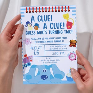 May include: Blue's Clues birthday party invitation with a blue dog character, a red bucket, a yellow sun, and a clock. The invitation says "A Clue! A Clue! Guess Who's Turning Two!" and includes the date, time, and address of the party.
