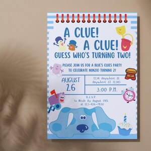 May include: A blue and white invitation card with a cartoon character from the show Blue's Clues. The card says "A Clue! A Clue! Guess Who's Turning Two!" and includes details for a birthday party.