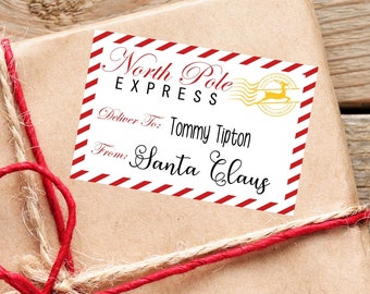 May include: A rectangular North Pole Express shipping label with red and white diagonal stripes on the edges. The text reads North Pole Express, Deliver To: Tommy Tipton, and From: Santa Claus, featuring a gold reindeer stamp graphic.