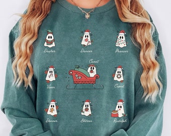 May include: Teal green sweatshirt with a Christmas-themed design featuring ghost reindeer with names like Dasher, Dancer, Prancer, Vixen, Comet, Cupid, Donner, Blitzen, and Rudolph.