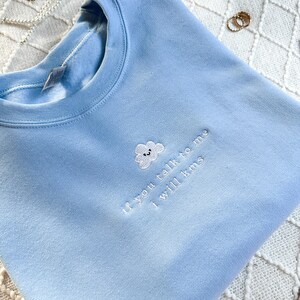 May include: A light blue sweatshirt with a white embroidered cloud and the text "If you talk to me I will kms".