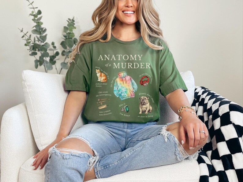 May include: A green t-shirt with the text "Anatomy of a Murder" and illustrations of a cat, a tie-dye hoodie, headphones, and a dog. The illustrations are surrounded by text.