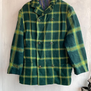 May include: A double-breasted green and yellow plaid wool coat. The coat has a notched collar, two rows of buttons, and two front pockets. The interior lining is a blue and yellow plaid pattern.