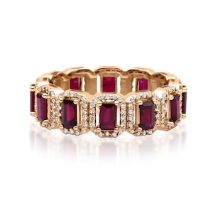 May include: A gold-toned ring featuring rectangular, deep red gemstones, each surrounded by a halo of small, clear stones. The ring's band is also gold-toned, creating a continuous pattern of color and sparkle. The ring is designed for women.