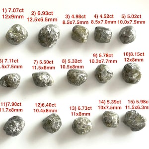 Puede incluir: Se muestran quince diamantes en bruto de diferentes tamaños y quilates. Cada piedra tiene una forma única y un tono ligeramente gris. Las medidas en mm y quilates se enumeran junto a cada piedra, como "1) 7.07ct 12x9mm."