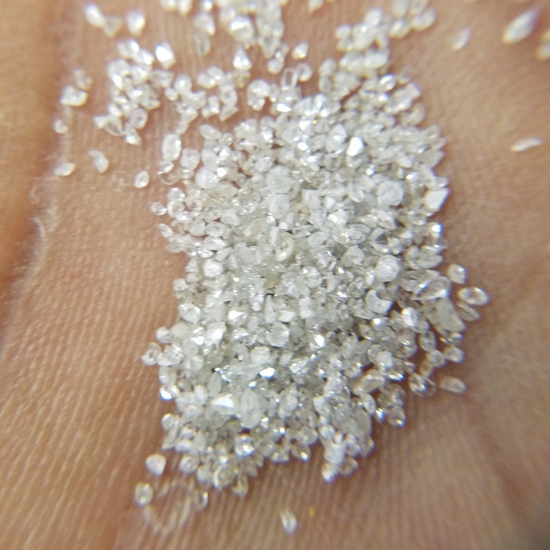 Puede incluir: Primer plano de un mont&oacute;n de peque&ntilde;as piedras preciosas claras y brillantes. Las piedras est&aacute;n dispersas sobre una superficie, captando la luz y creando una exhibici&oacute;n brillante. Las gemas parecen estar talladas en bruto y tienen un aspecto natural y sin pulir.