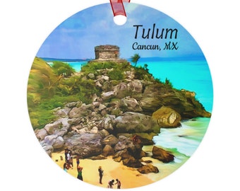 May include: A round ornament featuring a watercolor painting of a Mayan ruin on a cliff overlooking a turquoise ocean. The text "Tulum Cancun, MX" is printed on the ornament.