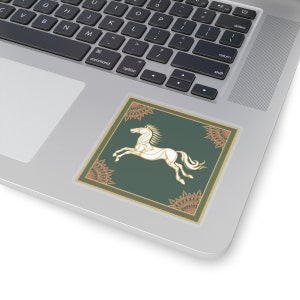 May include: A white horse with a flowing mane and tail, leaping forward, is depicted on a green background. The horse is surrounded by a decorative border with orange and gold accents.