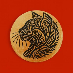 以下が含まれることがあります： 丸い金色の装飾品で、黒い猫の横顔が描かれています。猫のシルエットは、複雑で様式化された葉のような模様で埋められています。背景は鮮やかな赤色です。