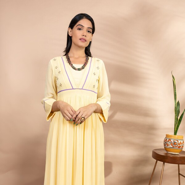 Une femme indienne jaune porte une robe de créateur de mariage pakistanais