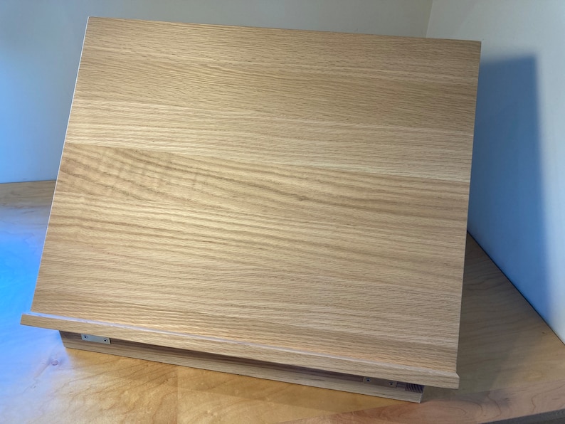 K&ouml;nnte beinhalten: Ein helles Holz-Staffelei mit einer schr&auml;gen Oberfl&auml;che, perfekt zum Ausstellen von Kunstwerken oder zum Schreiben.