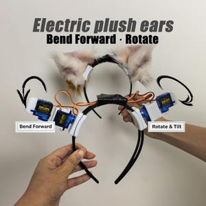 Peut inclure: Serre-tête avec oreilles en peluche électriques, servomoteurs et câblage. Le texte indique : Electric plush ears, Bend Forward, Rotate, Bend Forward, Rotate & Tilt. Le serre-tête comporte des oreilles en fausse fourrure claire et des composants.