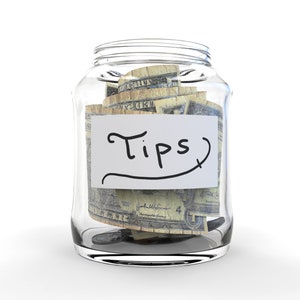 May include: A glass jar filled with US dollar bills, labeled "Tips".