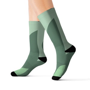 May include: A pair of green and white socks with a geometric pattern. The socks are made of a soft, comfortable material and are perfect for everyday wear.