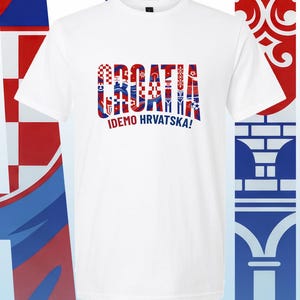 May include: A white short-sleeved t-shirt featuring the word CROATIA in large, bold letters filled with a red, white, and blue checkered pattern. Below the word, the text IDEMO HRVATSKA! is printed in dark blue, sans-serif capital letters.