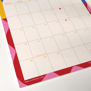 May include: A monthly calendar with a cream-colored background and a grid layout. The days of the week are across the top in yellow. The calendar has a red, pink, yellow, and blue border. The website www.ecofaves.com is at the bottom.
