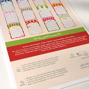 May include: A colorful calendar print with monthly calendar blocks in various patterns and colors. The print includes text about eco-friendly paper made from bamboo and cotton, with the words "See the good in every day."