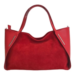 Puede incluir: Un bolso tote de ante rojo con detalles de cuero y una cremallera plateada. El bolso tiene dos asas superiores y un logotipo plateado que dice "LORO PIANA".