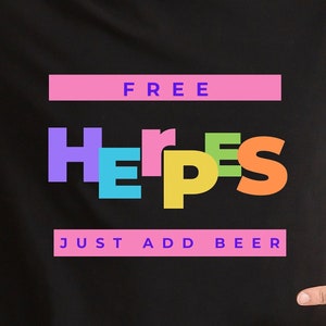 May include: A black t-shirt with the text "FREE HERPES JUST ADD BEER" in colorful letters. The word "FREE" is in pink, "HERPES" is in rainbow colors, and "JUST ADD BEER" is in pink.