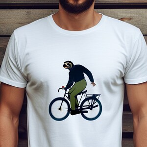 May include: A white t-shirt with a graphic of a sloth riding a bicycle. The sloth is wearing a blue shirt and green pants.