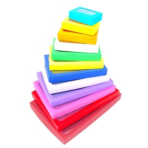 May include: A stack of colorful boxes with clear windows, arranged in a pyramid shape. The boxes are red, pink, purple, white, blue, yellow, green, and light blue.