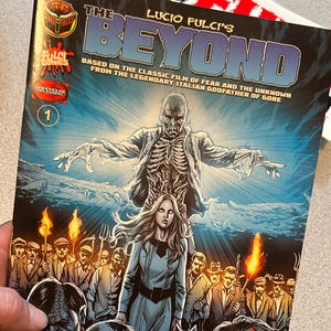 Puede incluir: Portada de cómic con una figura esquelética con ojos brillantes, una mujer con un vestido azul y un grupo de zombis. El título es "Lucio Fulci's Beyond" y el lema es "Basado en la película clásica de miedo y lo desconocido del legendario padrino italiano del gore".