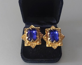 Brincos vintage em formato de estrela dos anos 80, com pedra azul mística e detalhes em tom dourado.
